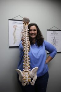 Dr. Adkins holding a human spine model